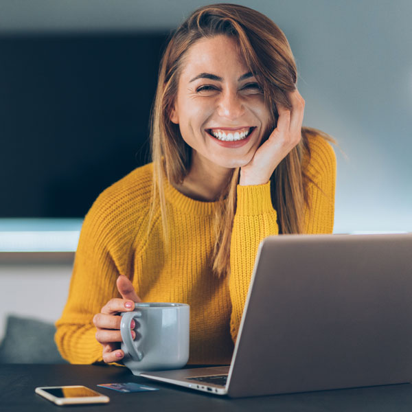 woman smiling while working on laptop