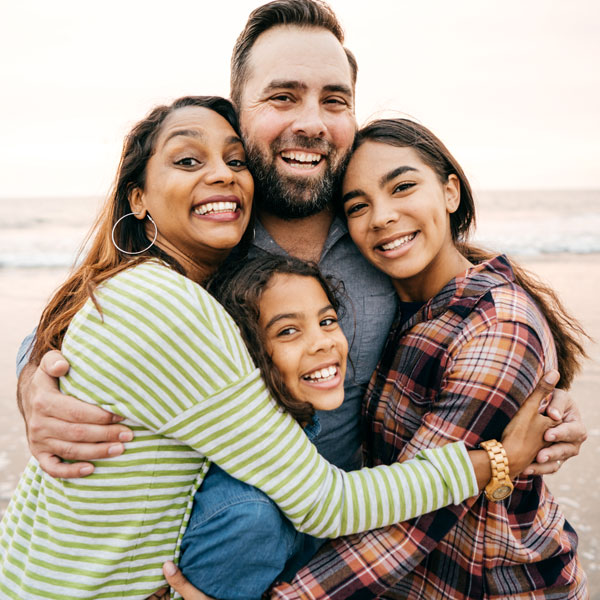 family of four smiling together