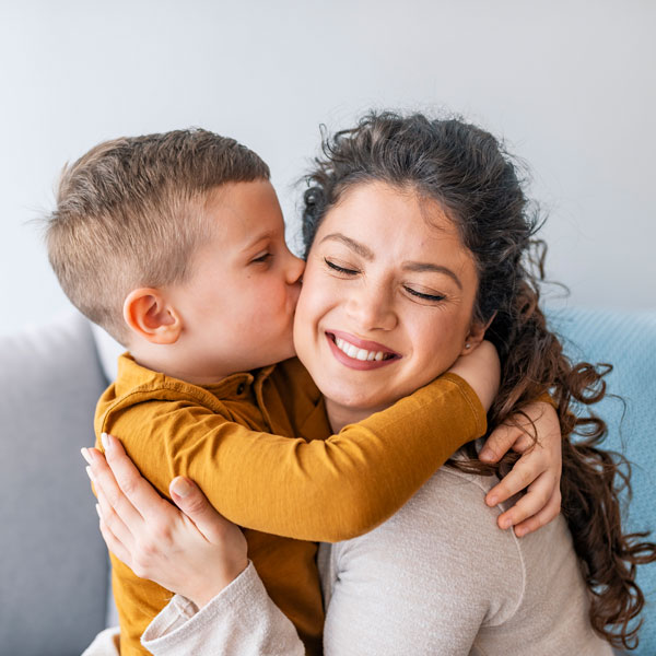 little boy kissing his mom on the cheek